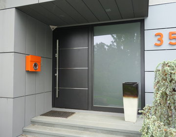 Ultra modern front door in gray metallic finish with large sidelight frosted glass.