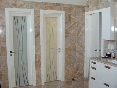 State of the art Master Bath enhanced with glossy ivory doors with designer glass