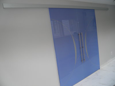 Double glass door sliding on wall, blue color, frosted decor, aluminum track, designed and crafted in Italy.