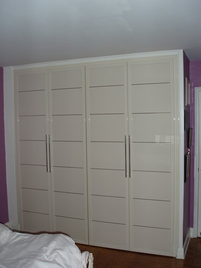 Bedroom closet in ivory glossy finish with shiny chrome horizontal stripes, matching color door pulls