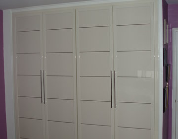 Bedroom closet in ivory glossy finish with shiny chrome horizontal stripes, matching color door pulls